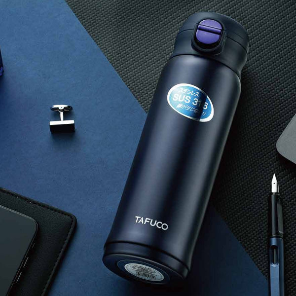 כוס תרמית לקפה ותה TAFUCO 420-500 מל' בצבע כחול כהה מונח על שולחן עבודה