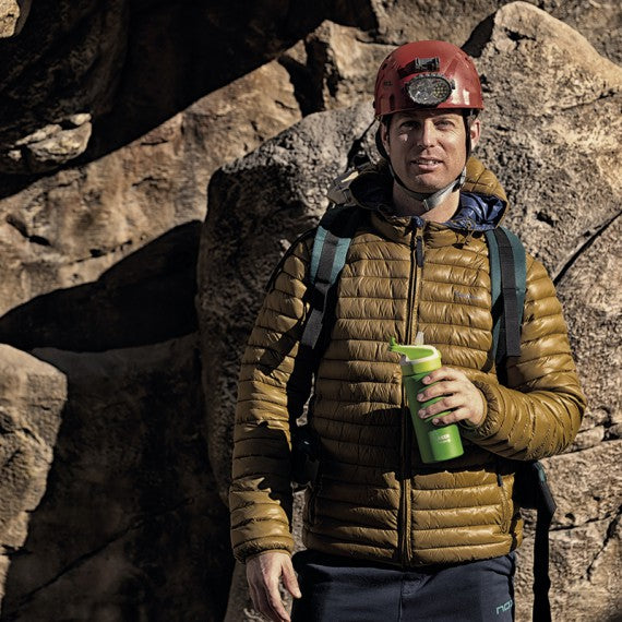 גבר בטיול הרים עוצר להתרענן עם בקבוק שתיה לאקן תרמו סאמיט ספורט עם פקק קשית 350-1000 מ"ל בצבע ירוק ביד